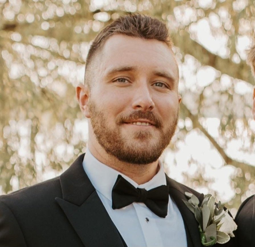 Devan Kealey in a tuxedo, smiling
